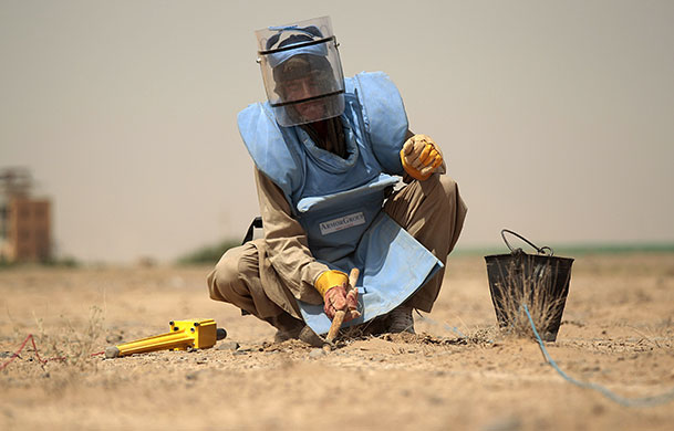 24 hours : Kandahar, Afghanistan: An Afghan deminer searches for unexploded ordnance 