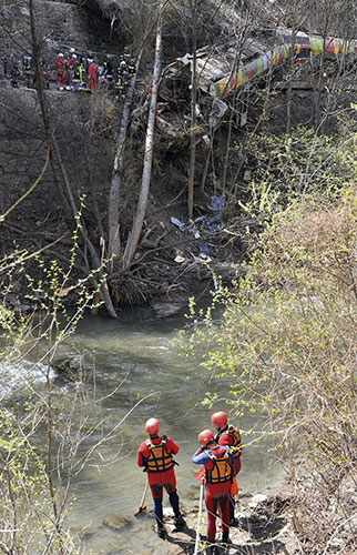 Train derailment: Firefighters stand on the banks of the Adige river