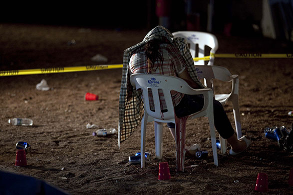 24 hours in pictures: Ciudad Juarez, Mexico: Covered by a shirt, the body a woman sits on a chair