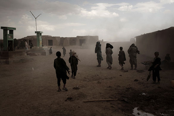 24 hours in pictures: Marjah, Afghanistan: People look for shelter as a sandstorm approaches