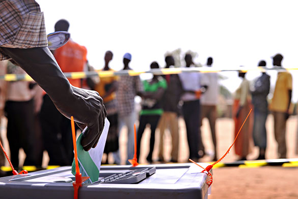 Sudan elections: A Sudanese voter casts a ballot as other wait in line