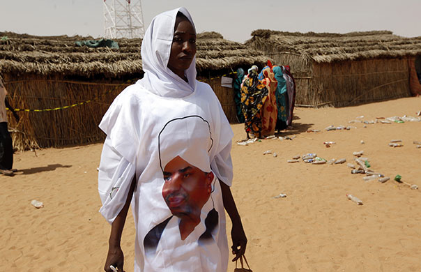 Sudan elections: A female election worker with a picture of Sudan's Omar al-Bashir 