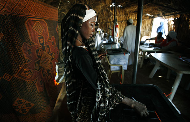 Sudan elections: A Sudanese refugee woman casts her vote at a polling station 
