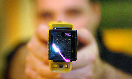A police officer demonstrating a Taser gun
