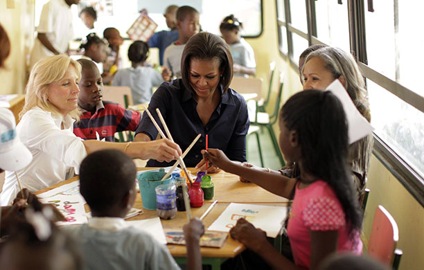 Michelle Obama in Haiti: Michelle Obama sits with children at a local welfare project