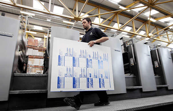 Printing Labour leaflets: An employee of prepares to load a sheet into a CutStar sheeter