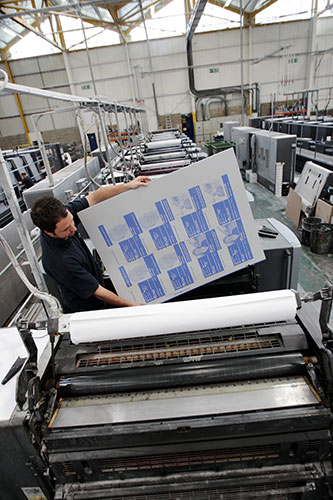 Printing Labour leaflets: An employee of Anton Group Printers loads a sheet into a CutStar sheeter 
