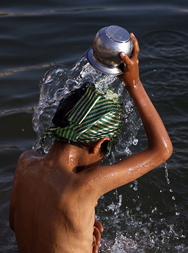 Sikh festivals: An Indian child pours holy water at the Golden Temple Amritsar