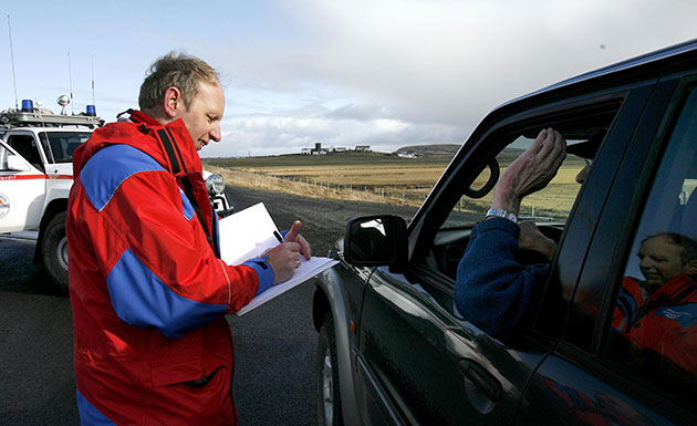 Iceland volcano eruption: An emergency worker records a driver's details