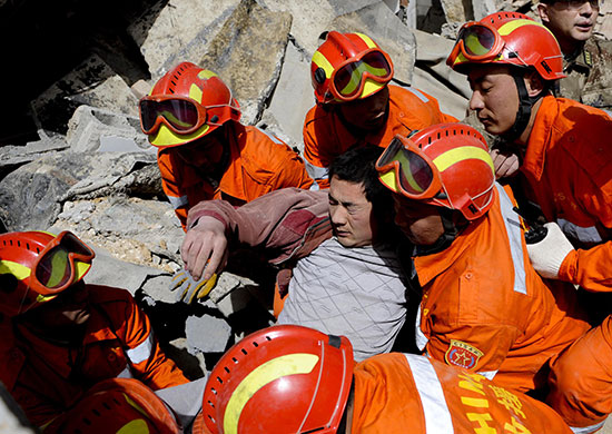 china earthquake: Rescuers carry an injured man in Yushu, Qinghai province
