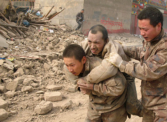 china earthquake: People's Liberation Army soldiers carry a survivor 