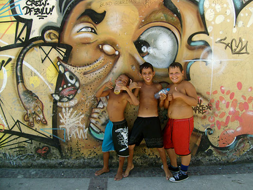 Te Vejo Maré: Young children pose in front of one of the fine graffiti peices in Maré