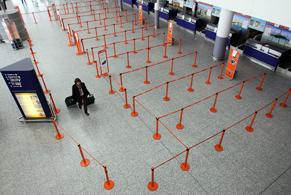 Volcano disruption: A woman walks in the empty departure hall at Bristol Airport 