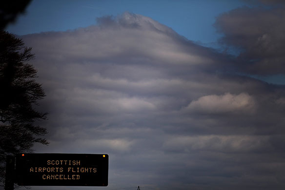 Volcano disruption: Traffic pass a motorway sign warning of flight cancellations