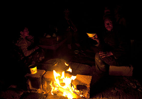 china earthquake: Tibetan people have dinner around a fire in  Jiegu