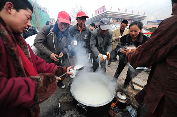 china earthquake: Tibetan Buddhist monks serve congee to earthquake survivors in Jiegu