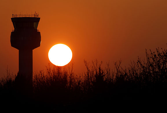 Volcanic sunsets: The sun sets behind the air traffic control tower at East Midlands airport