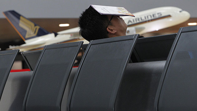 Travel chaos: A passenger rests on the empty seats at Zurich airport