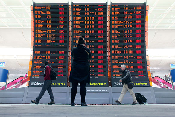 Travel chaos: Travellers pass a board showing cancellations Charles de Gaulle airport