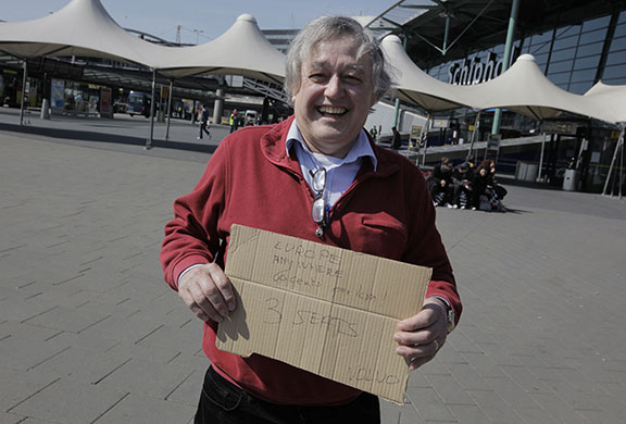 Travel chaos: A man holds a sign offering to drive stranded travellers to any location