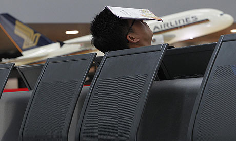 A passenger rests on empty seats of a deserted terminal at Zurich airport in Kloten