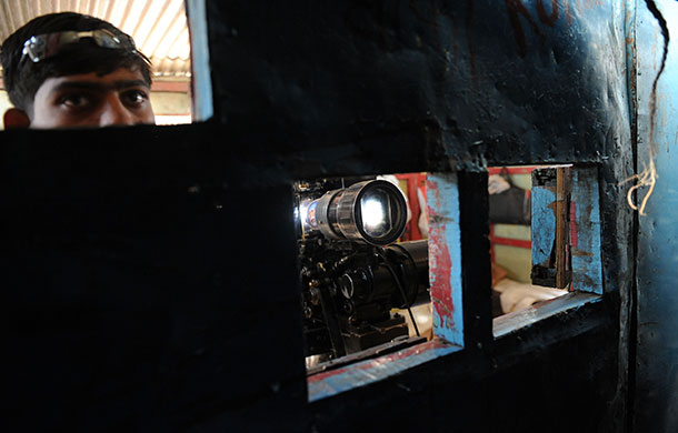24 hours: Shikhar Shingnapur, India: A projectionist watches a matinee show