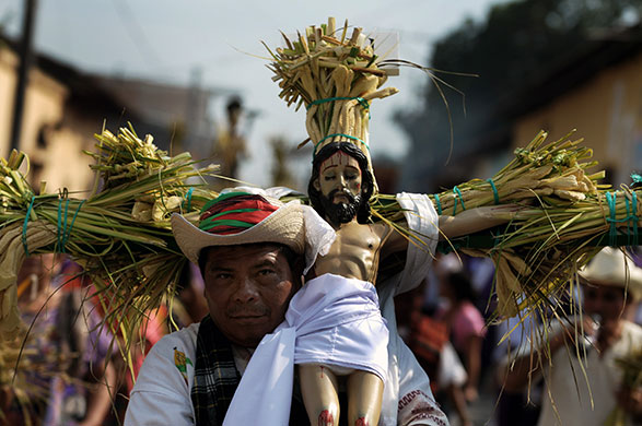 24 hours: Izalco, El Salvador: A member of a brotherhood carries an image of Christ