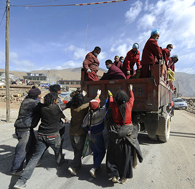 China earthquake: People chase a truck as Tibetan Buddhist monks distribute relief goods