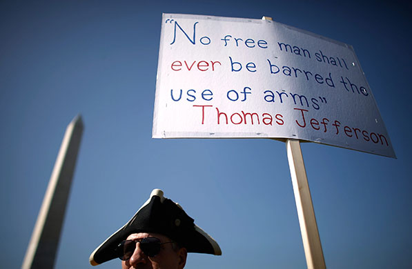 24 hours in pictures: Washington, DC, USA: A man stands next to a sign at a pro-gun rally