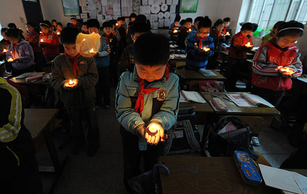 china quake mourning: Hefei: Students hold candles in their classroom