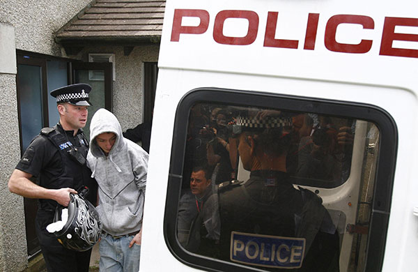 election week 3: A police officer leads away a youth who threw an egg at  David Cameron