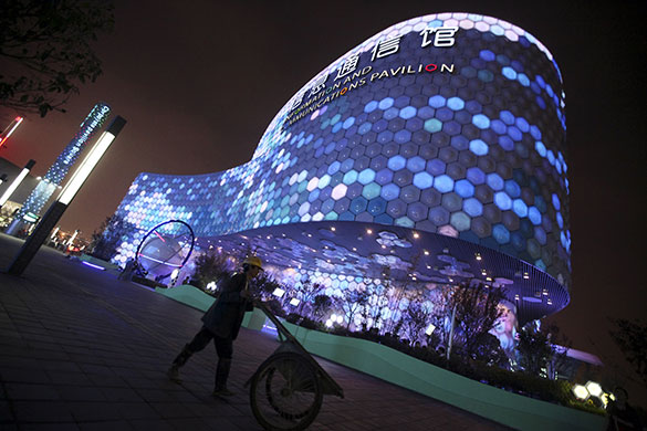 Shanghai Expo: A construction worker near the illuminated Chinese Information Pavilion