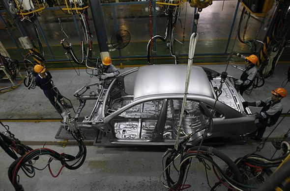 Week in Business: Workers assemble a car at the GM Daewoo Vietnam automaker plant in Hanoi