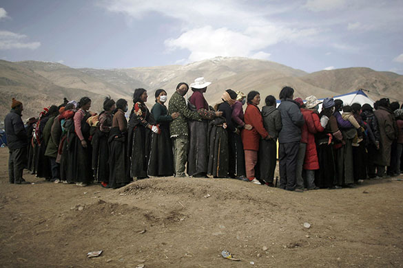 24 hours in pictures: Gyegu, China: Ethnic Tibetans queue to receive aid