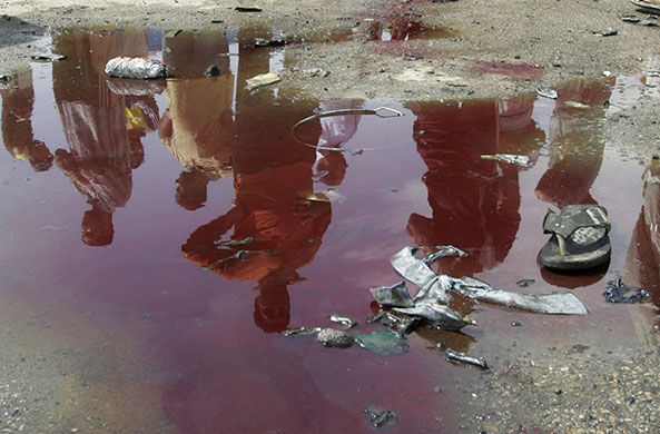 Baghdad bombings: Residents are reflected in a pool of blood