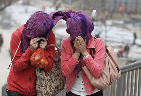 24 hours in pictures: strong winds on a street in Beijing