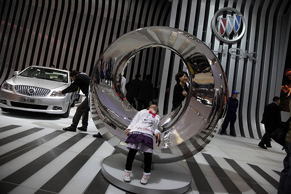 Beijing car show: A child rests on a sculpture at the Buick booth