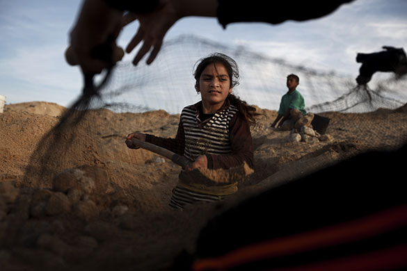 24 hours in pictures: Khan Younis, Gaza Strip: Girls sift sand for gravel