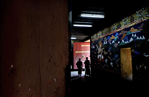24 hours in pictures: Paro, Bhutan: Buddhist monks walk past a mural at a monastery