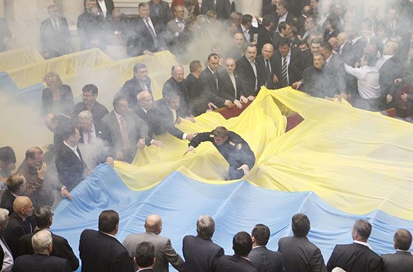 Ukraine parliament: A fireman, centre, rushes to extinguish a smoke bomb