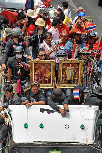 Thailand protests: Red Shirts in the convoy hold portraits of the Thai king and queen 