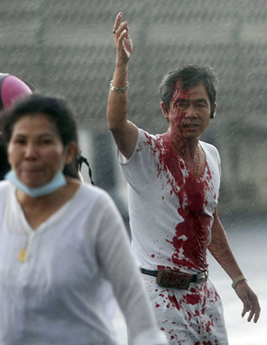 Thailand protests: An injured protester waves for help