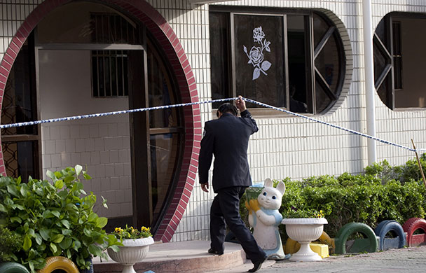 China school violence: A police officer enters a building where students were attacked in Taixing