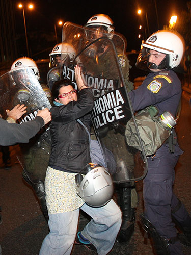 Greece protests: Riot police restrain a protester during clashes in central Athens,