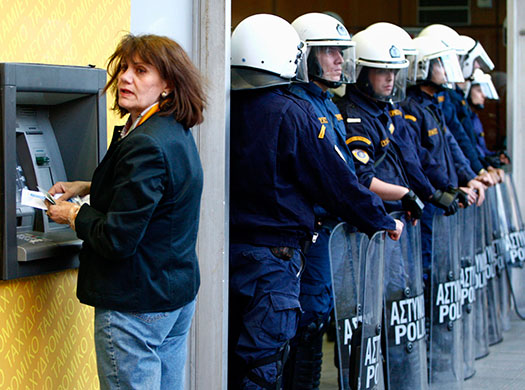 Greece protests: A woman at ATM during a rallyoutside Greece's Finance Ministry in Athens