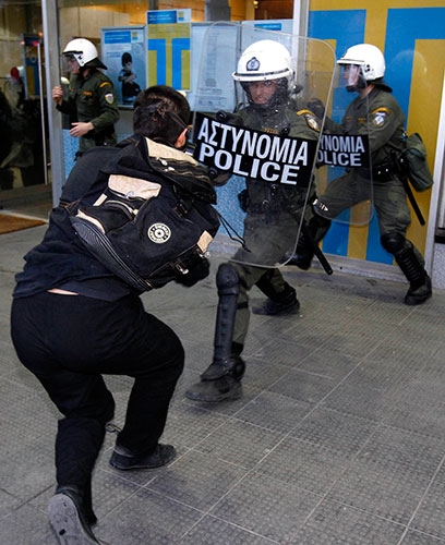 Greece protests: A protester clashes with a policeman outside Greece's Finance Ministry