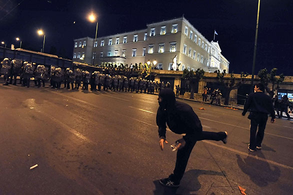 Greece protests: Protesters bottles towards riot policemen protecting the greek parliament