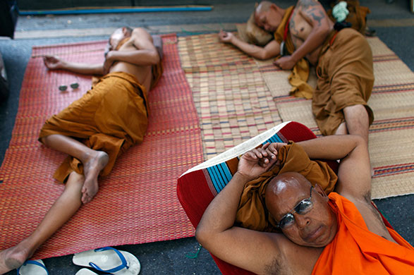 24 hours in pictures: buddhist monks rest as political turmoil continues in thailand