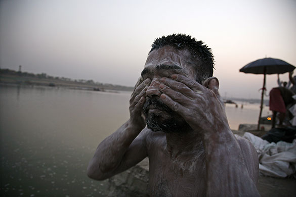 24 hours in pictures: A man applying mud on his body on the banks of river Ganges in Allahabad