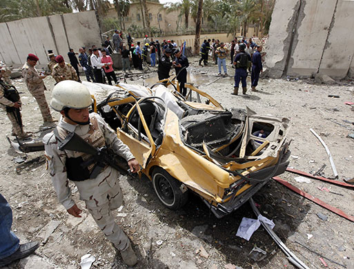 Baghdad explosions: Security forces inspect the site of a car bomb attack